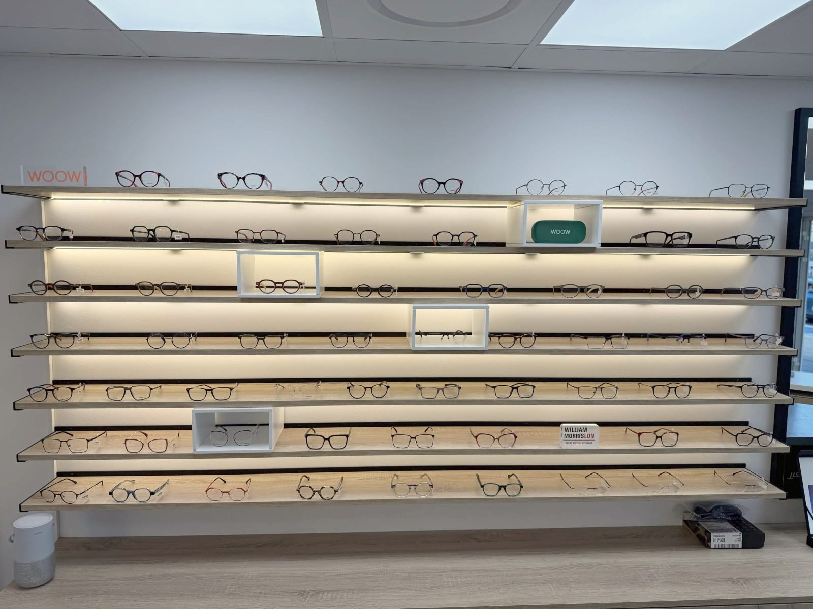 Un mur de montures de vue sur des étagères lumineuses